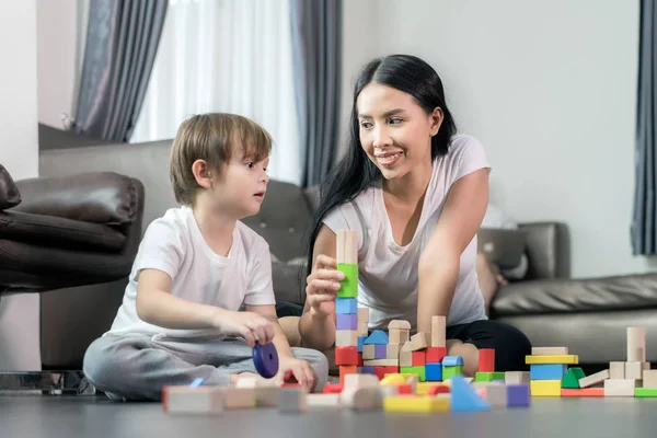 Niño asiático y madre jugando juguete de madera en la sala de estar. Feliz fami. — Foto de Stock