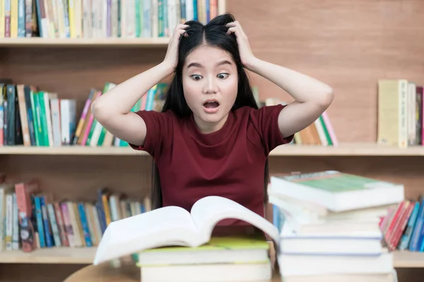 Jovem estudante asiático sob pressão mental durante a leitura livro pre — Fotografia de Stock