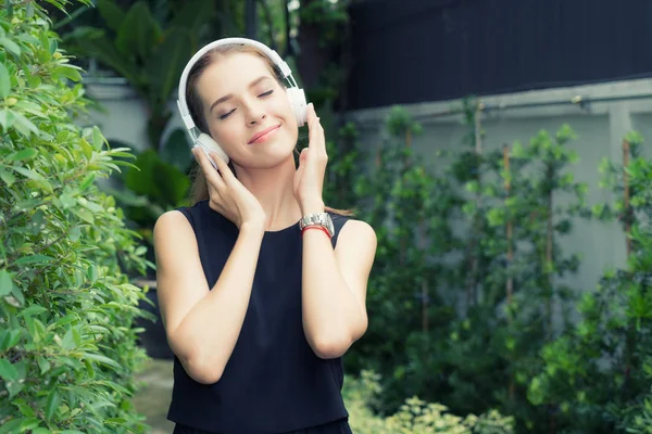 Beautiful Russian woman listen to music while her eyes close wit — Stock Photo, Image