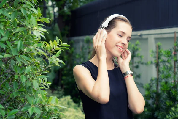 Beautiful Russian woman listen to music while her eyes close wit — Stock Photo, Image