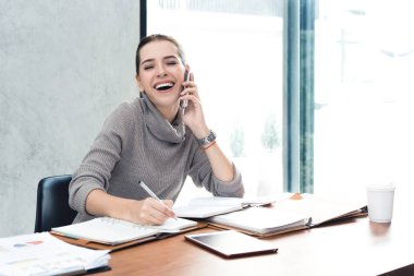 Memur cep telefonu konuşurken beyaz sevimli genç ofis çalışanı