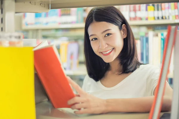 Alegre estudiante asiática leyendo libro durante el descanso entre —  Fotos de Stock