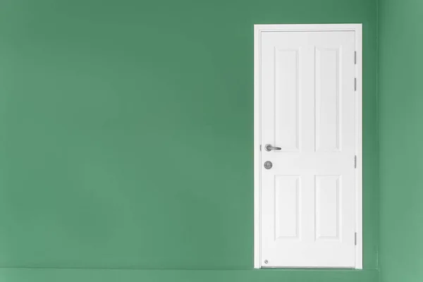 Closed white door on green wall at home. — Stock Photo, Image