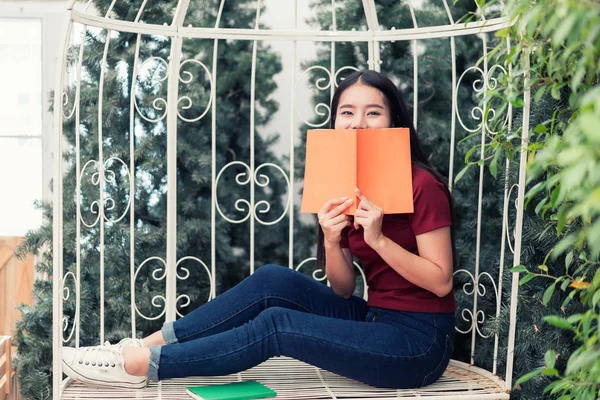 Asian young woman student reading book at garden in university. — Stock Photo, Image