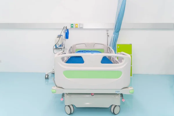 Cama de hospital vazia com equipamentos médicos na sala de recuperação em ho — Fotografia de Stock