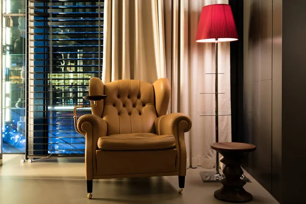 Leather armchair coffee table and floor lamp in lobby at hotel.