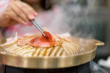 Çubuk ızgara ızgara Kore domuz yakiniku ile tutan el