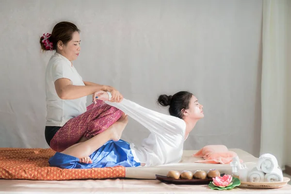 Тайский массажист делает спа-массаж для молодой азиатки в спа-сале — стоковое фото