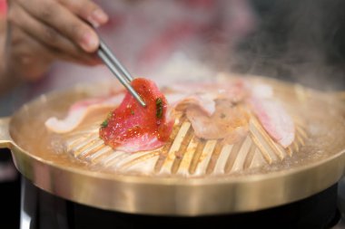 Çubuk ızgara ızgara Kore domuz yakiniku ile tutan el