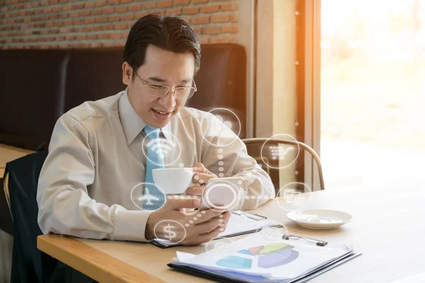 Empresário com uma xícara de café lendo seu telefone inteligente em um ca — Fotografia de Stock