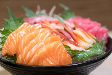 Karışık dilimlenmiş balık sashimi siyah kase buz üzerinde. Sashimi somon T