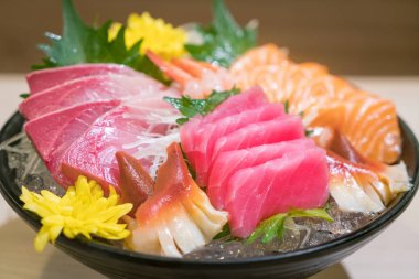 Karışık dilimlenmiş balık sashimi siyah kase buz üzerinde. Sashimi somon T