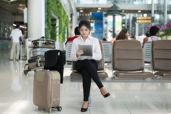 彼女のタブレット コンピューティングを使用して空港、アジアの若い女性旅客 — ストック写真