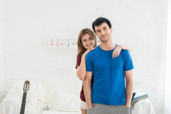 Belo jovem casal está abraçando, olhando para a câmera e sorrindo — Fotografia de Stock