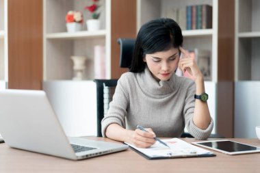 Oturan bir güzel Asyalı genç iş kadını portresi