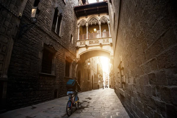 Barcelona people biking bicycle in Barri Gothic Quarter and Brid