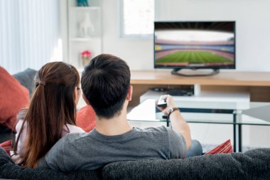 Arkadan görünüş futbolda liv televizyon izlerken Asya çift