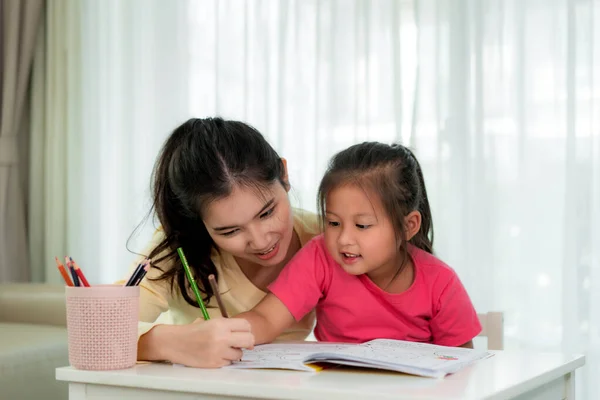 Asian mother playing with her daughter drawing together with col — Stock Photo, Image