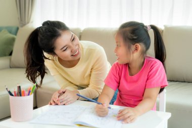 Asyalı anne kızıyla oynuyor.