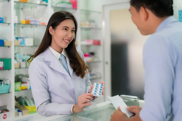 Confiado joven farmacéutica asiática con un encantador amistoso s —  Fotos de Stock