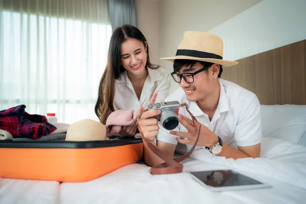 Feliz asiático pareja desembalaje maleta en cama en dormitorio cuando el — Foto de Stock