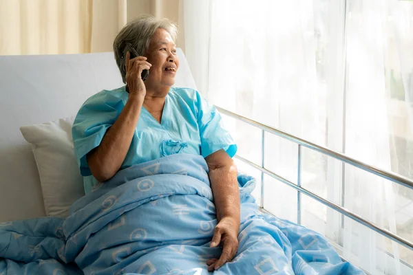 Asiatique personnes âgées utilisant bavarder avec la famille sur son téléphone mobile — Photo