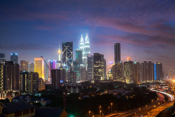 Kuala Lumpur City skyline and skyscraper with highway road at ni — Stock Photo, Image