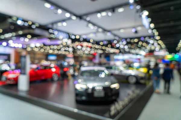 Fondo borroso de los coches nuevos exhibidos en la sala de exposición de lujo con — Foto de Stock