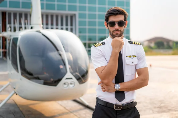 Portrait of handsome commercial pilot in captain white uniform s