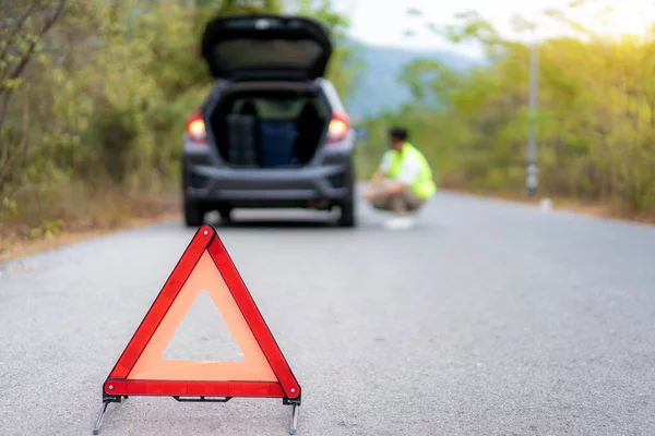 Breakdown triangle sign on road with worried Asian man repairing — Stock Photo, Image