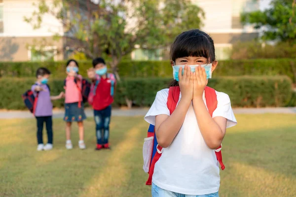 Azjatka Dziewczyna Przedszkolak Ubrany Zdrową Maskę Twarzy Kichać Przyjaciółmi Tle — Zdjęcie stockowe