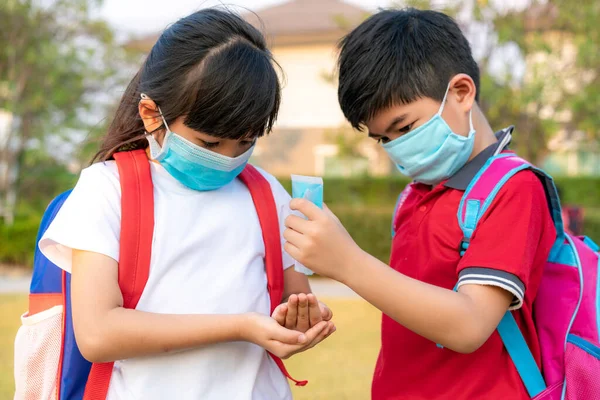 Asiatische Schüler Tragen Hygienemaske Und Pressen Alkoholgel Von Der Flasche — Stockfoto