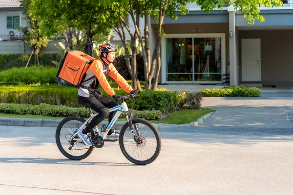 アジア人男性宅配自転車で街中の食べ物を配達し 家までの距離やレストランからの熱い食べ物の配達 食べ物の配達とオンラインショッピングの概念 — ストック写真