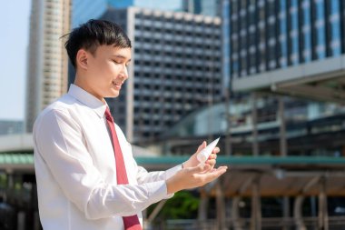 Şehirdeyken alkol antiseptik jeli kullandıktan sonra cilt kuruluğu ve tahriş olması için günlük yaşamlarının el kremi ya da nemlendiricisi kullanan bir iş adamı.