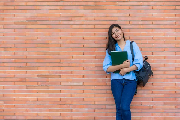 Asiático Sorrindo Mulher Estudante Segurando Livro Posando Fundo Tijolo Campus — Fotografia de Stock