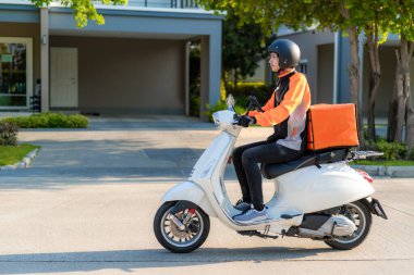 Scooter 'lı Asyalı kurye şehrin sokaklarına sıcak yemek teslimatı yapıyor. Yol ve restoranlardan eve yemek teslimatı ve online alışveriş kavramına kadar..