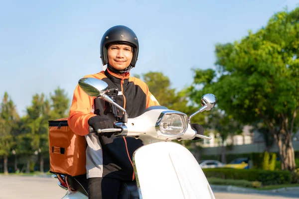 亚洲男子骑摩托车递送食物至市区街道 并附有由外卖道和餐馆到家的热食递送 速递食物和网上购物的概念 — 图库照片