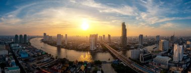 Bangkok 'un iş bölgesi silueti ve Chao Phraya Nehri ile birlikte günbatımında Bangkok, Tayland' da ofis gökdelenleri. THailand turizmi, modern şehir hayatı, ya da iş finans ve ekonomi kavramı