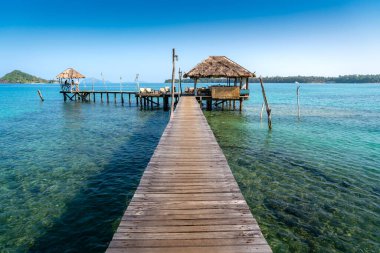 Trat, Tayland 'da Koh Mak' ta açık gün gökyüzü olan bir kulübe ve denizde tahta bar. Manzara ve seyahat, ya da yaz konseptinde doğa ve gezi