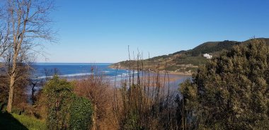 Dağları, mavi gökyüzünü ve Bask ülkesindeki beyaz bulutları barındıran Urdaibai biyosferinin muhteşem manzarası. Muhteşem doğal manzara.