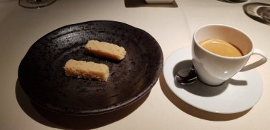 Sıcak bir masada iki hamur işi ile nefis bir fincan kahve.