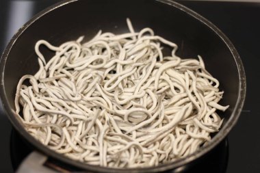 Siyah tavada sarımsaklı bebek yılan balıkları.