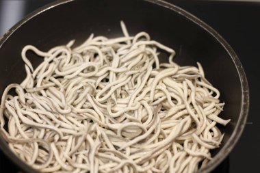 Siyah tavada sarımsaklı bebek yılan balıkları.