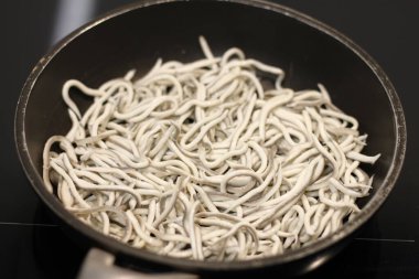 Siyah tavada sarımsaklı bebek yılan balıkları.