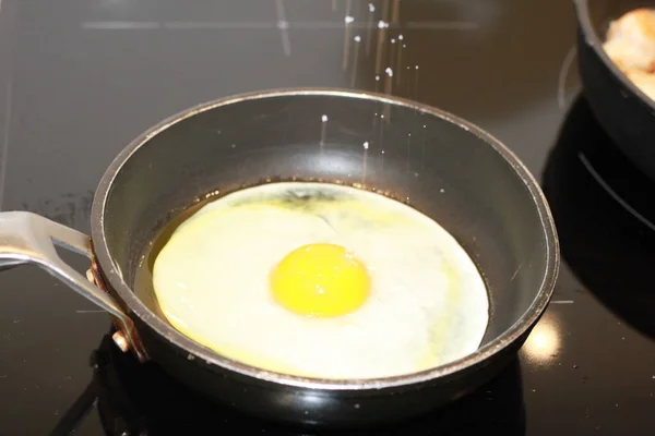 cooking a fried egg in a pan