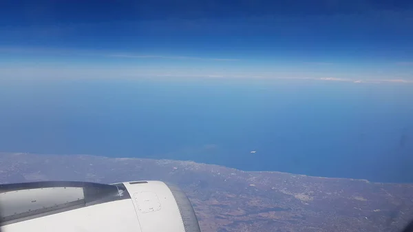 从另一架飞得更高的飞机上看到的飞越海岸的飞机的空中景观 — 图库照片