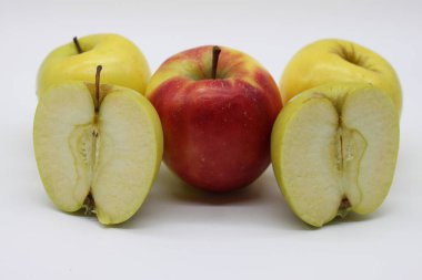 Beyaz arka planda altın ve kırmızı elmaları bir bütün olarak kestik.