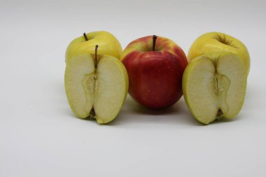 Beyaz arka planda altın ve kırmızı elmaları bir bütün olarak kestik.