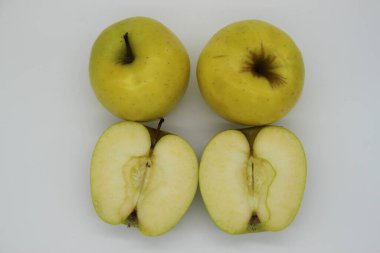 Altın elmalar bütün ve beyaz arka planda ikiye bölünmüş.