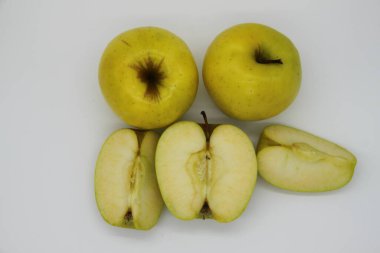 Altın elmalar bütün ve beyaz arka planda ikiye ve çeyrekliklere bölünmüş.